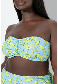 Bandeau bikinitoppi vaaleansinisessä värissä, jossa on keltainen kukkakuosi. Sisältää rypytyksiä ja turkooseja yksityiskohtia keskellä. sileä pinta.