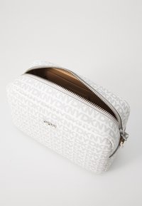 Borsa cosmetica in tessuto bianco con motivo a logo ripetuto, cerniera argentata e superficie interna liscia. Forma rettangolare con angoli arrotondati.