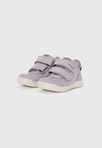 Lila Wildlederschuhe für Kinder mit doppeltem Klettverschluss, runder Zehenform und einer weißen Gummisohle. Strukturierte Textilauskleidung sichtbar.
