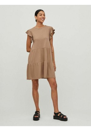 Braunes Baumwollkleid mit kurzen, rüschengesäumten Ärmeln und mehrlagigem Design, das eine lockere Passform und einen leicht ausgestellt Rock hat. Schwarze Plateausandalen.