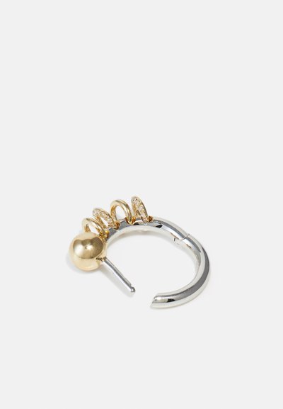 Guld- och silverörhänge i hängande ringar med en sfärisk accent, flera mindre ringar och en texturerad yta med glittrande detaljer.