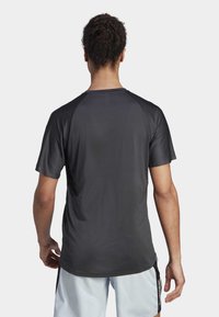 Svart atletisk T-shirt med korta ärmar och rund halsringning, tillverkad av lätt, fuktavledande tyg med en slät yta.