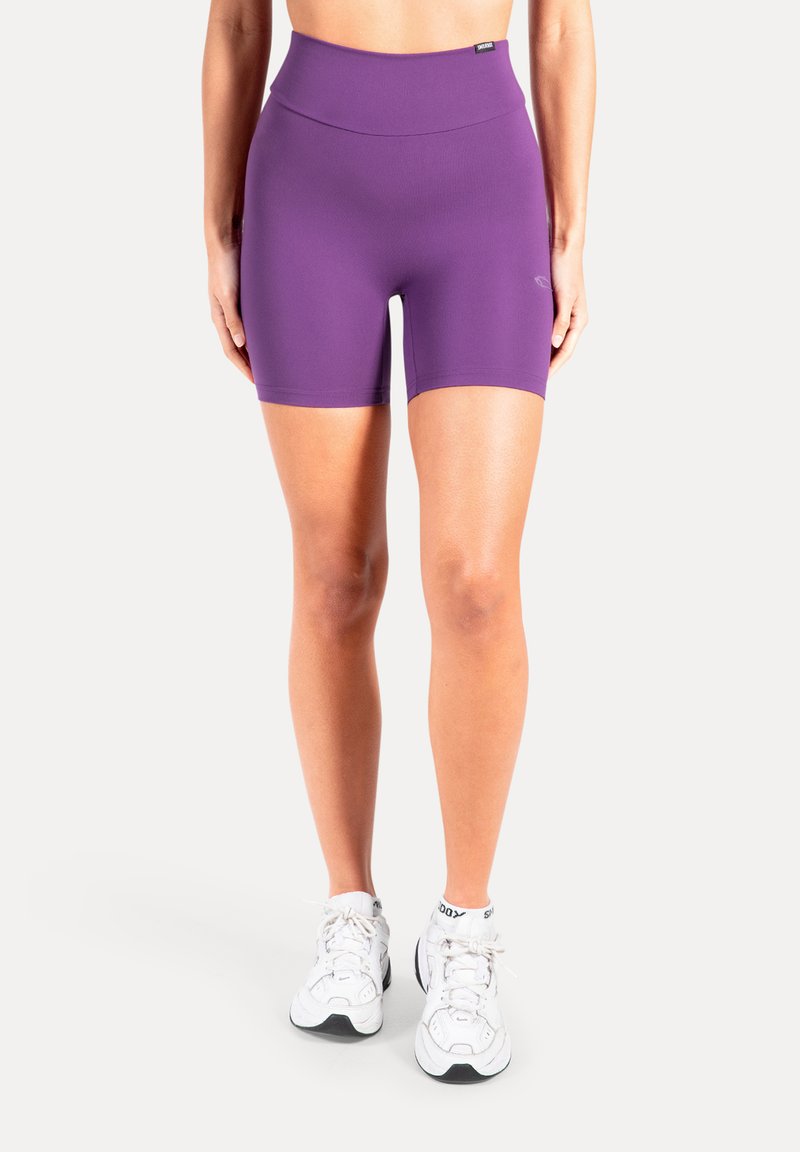 Lila högmidjade sportshorts med en slät textur, åtsittande design och en ren finish. Bärs med vita sportiga sneakers.