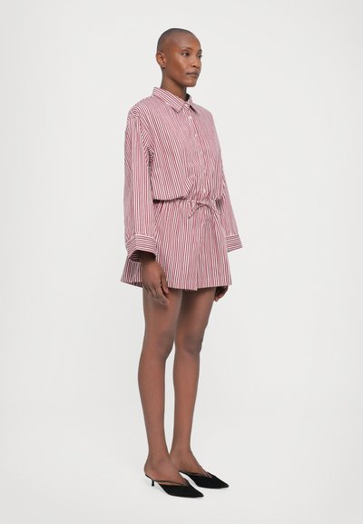 Striped red and white button-up dress shirt with an elastic waist and flared hem, paired with black slip-on heels. Smooth fabric and tailored fit.