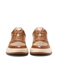 Brązowe skórzane sneakersy z beżowymi akcentami, z perforowanymi detalami, okrągłymi sznurowadłami oraz teksturowaną gumową podeszwą. Logo na języku.