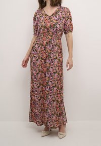 Robe longue fleurie avec manches bouffantes courtes, encolure en V, fond noir, fleurs roses et orange, fentes latérales, tissu fluide.