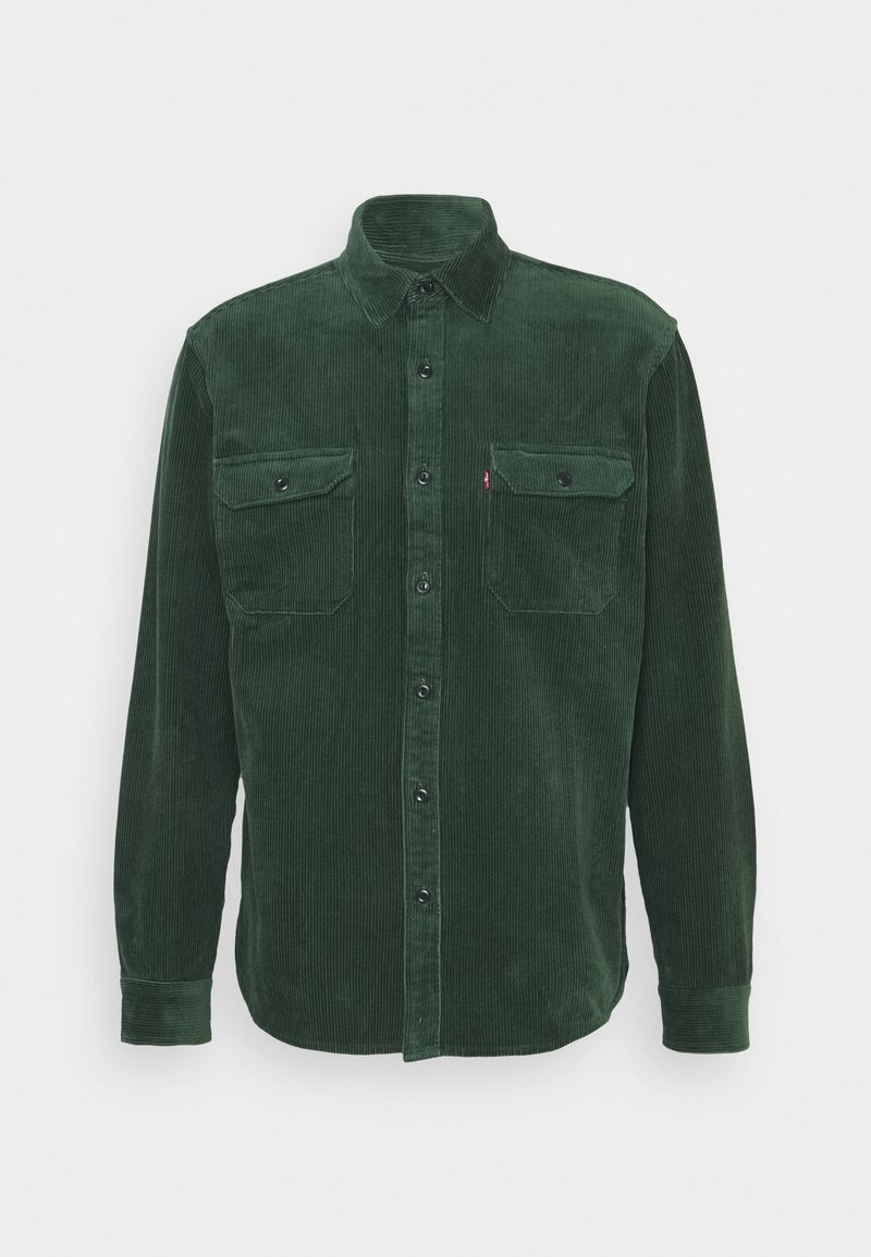 Chemise en velours côtelé vert foncé à manches longues, avec deux poches poitrine à boutons et une fermeture à boutons sur le devant.