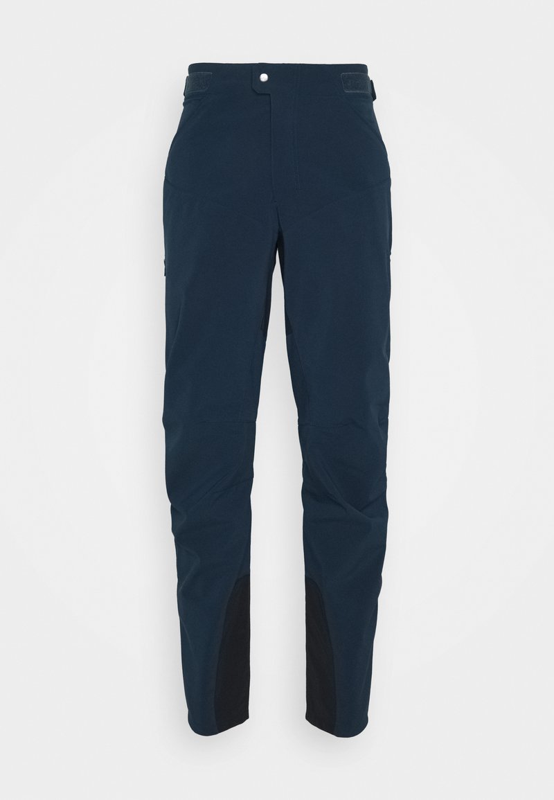 Calças azul-marinho com um design elegante, feitas de um tecido leve. Apresentam seções pretas reforçadas na parte inferior das pernas e um fecho de pressão frontal.