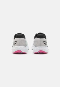 White athletic shoes with a textured gray upper, black accents, and pink rubber outsoles. Features a sleek design with logo detailing.