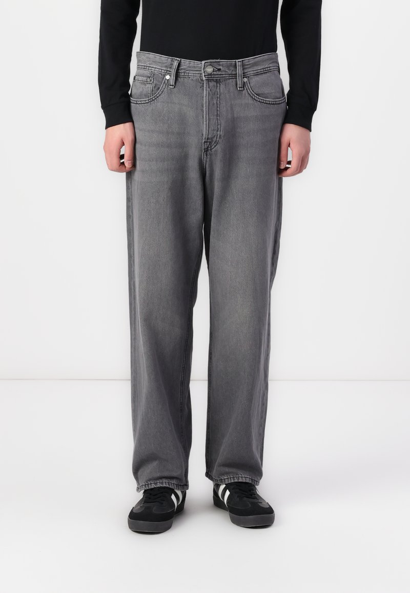 Grey denim jeans with a relaxed fit, featuring a classic five-pocket design, subtle fading, and contrasting stitching. Paired with black sneakers.