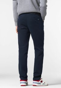Marineblaue Hosen mit schmaler Passform, hergestellt aus einem Baumwollmischgewebe, mit zwei Gesäßtaschen und einem strukturierten Bund.