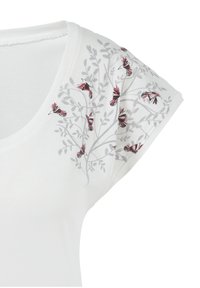 Camiseta blanca de manga corta con un diseño floral en gris y rojo en un hombro. Tejido suave con escote redondo y corte relajado.