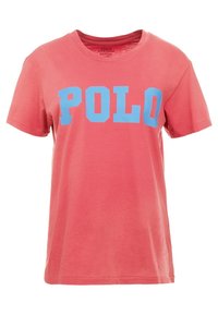 Korálové bavlněné tričko s modrým potiskem "POLO" v tučném písmu. Krátké rukávy a kulatý výstřih s měkkou texturou.