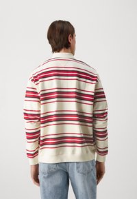 Gestreifter Sweatshirt in Creme, mit roten und schwarzen horizontalen Streifen, Rundhalsausschnitt, langen Ärmeln und gerippten Bündchen und Saum.