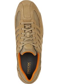 Krémové semišové tenisky s síťovanými panely, kulatou špičkou, šněrováním a oranžovým vnitřním podšívem. Mají gumovou podrážku a logo na jazyku.