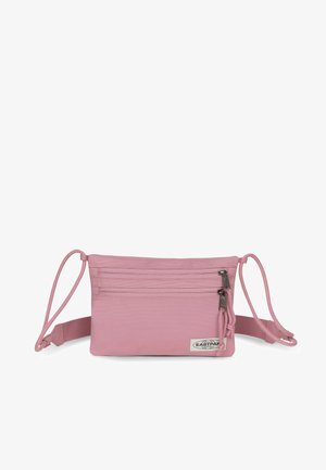 Růžová taška přes rameno z látky se dvěma zipovými přihrádkami, nastavitelnými popruhy a malou nášivkou s logem. Hladká textura a obdélníkový tvar.