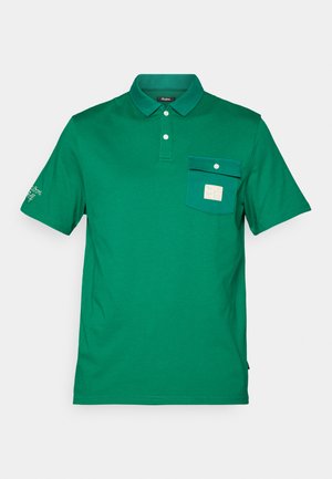 Grøn bomulds polo shirt med krave, korte ærmer, frontlomme med knaplukning og logo-patch på brystet.