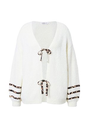 Cardigan blanc texturé avec un décolleté en V profond, des liens au motif léopard et des accents rayés sur les manches. Conception en tricot doux pour plus de chaleur.