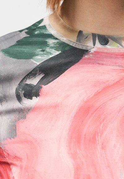 Κοντομάνικη μπλούζα με σχέδιο που συνδυάζει ροζ, πράσινο και γκρι χρώματα, με στρογγυλή λαιμόκοψη και εμφανή ραφή.