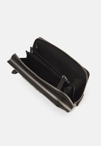 Black leather wallet with a zippered closure, featuring multiple card slots, a central pocket, and silver zipper detailing. Interior is fabric-lined.