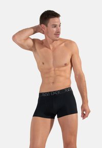 Boxer briefs neri realizzati in tessuto elasticizzato, con una ampia cintura elastica decorata con il logo del marchio. Il design è aderente e a vita media.