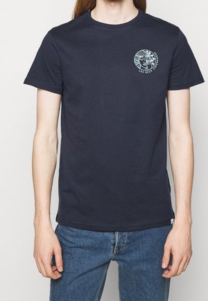 Granatowa bawełniana koszulka z krótkim rękawem i okrągłym dekoltem. Posiada okrągły nadruk graficzny na lewej piersi.