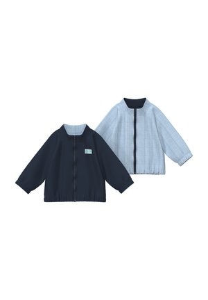 Twee kindervesten met lange mouwen en ritssluiting, één effen marineblauw met een klein logo en één lichtblauw met dunne verticale strepen.