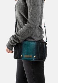 Schoudertas in een gradiënt van teal en zwart imitatieleer, met gouden hardware en een gestructureerd patroon. Inclusief verstelbare schouderband.