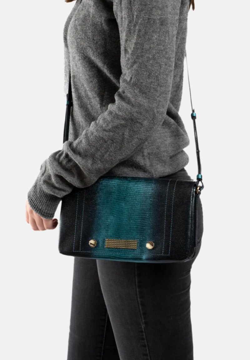 Schoudertas in een gradiënt van teal en zwart imitatieleer, met gouden hardware en een gestructureerd patroon. Inclusief verstelbare schouderband.