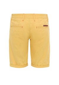 Gelbe Baumwollshorts mit geradem Schnitt, umgeschlagenem Saum und zwei Gesäßtaschen. Mit rotem Stich und einem kleinen Markenetikett am Bund.
