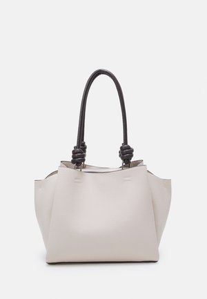 Jasnobeżowa torba na ramię z teksturowanej skóry, wyposażona w dwa ciemne plecione uchwyty oraz metaliczne akcenty. Otwarta u góry z miękkim, strukturalnym kształtem.