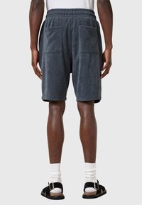Grijze badstof shorts met een relaxte pasvorm, elastische tailleband en twee grote achterzakken. Beschikt over een gladde textuur en een lengtes boven de knie.