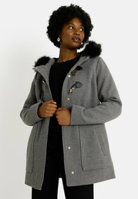 Abrigo de mezcla de lana gris con capucha de piel sintética, herrajes en tono dorado, cierres tipo toggles y bolsillos laterales, que presenta un corte relajado y una longitud ligeramente mayor.