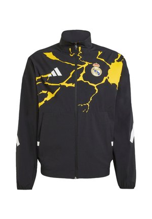 Black zip-up jacket with a yellow cracked design, featuring a Real Madrid logo and white accents on the arms. Made of lightweight material.