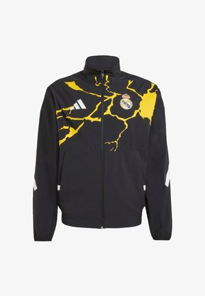 Black zip-up jacket with a yellow cracked design, featuring a Real Madrid logo and white accents on the arms. Made of lightweight material.