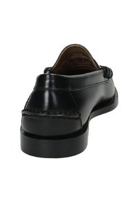 Scarpa loafer in pelle nera vista dal retro, con cuciture visibili e tacco basso e piatto su uno sfondo bianco.