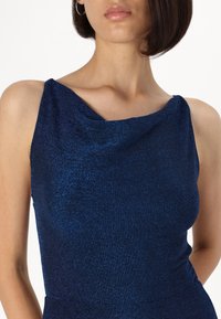 Navy blue sleeveless dress with a draped neckline, made of a shimmering fabric, featuring a slim fit and smooth texture.