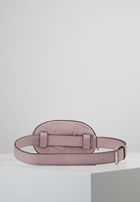 Pink leather belt bag with a quilted design, oval shape, and adjustable strap. Features two secure buckles for attachment.
