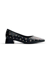 Zapato de charol negro con punta afilada y tacón bajo en bloque. Acentuado con ojales de metal en tono dorado en diferentes tamaños a lo largo de la parte superior.