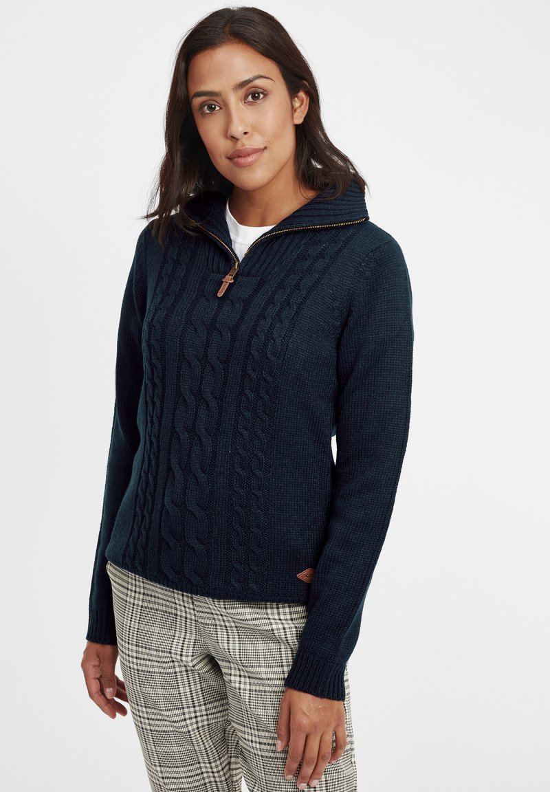 Navy knit sweater with a zippered collar, featuring a cable knit pattern and textured finish. A small leather logo patch is attached at the hem.