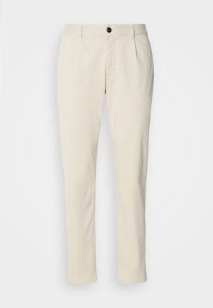 Bež boksarice iz bombaža s ravnim krojem, z enim gumbom za zapiranje in zankami za pas. Gladka tekstura, minimalno vidno šivanje.