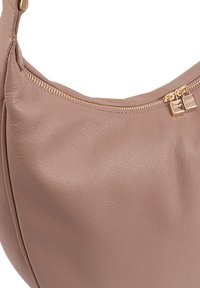 Lichtbruin leren handtas met een gestructureerd oppervlak, een gebogen ontwerp en een goudkleurige ritsluiting en hardwareaccenten.