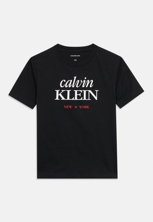 Czarny t-shirt z krótkim rękawem i okrągłym dekoltem, z białym napisem "calvin KLEIN" i czerwonym napisem "NEW YORK" z przodu.