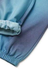 Ombre-blauer Sweatstoff, der von hellen zu dunklen Farbtönen übergeht, mit einem gerafften Bund am Handgelenk und glatter Textur.