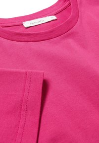 Fuchsia katoenen t-shirt met ronde hals, korte mouwen en gestikte accenten. Label leest "hessnatur," maat 36. Zachte textuur.