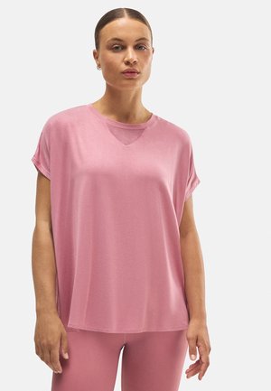 Top corto de color rosa con mangas cortas, detalle en V texturizado y un corte relajado. Material suave y textura lisa, combinado con leggings rosas a juego.