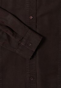 Braunes Button-Up-Hemd mit glatter Textur, langen Ärmeln und einem einzelnen Knopfverschluss an den Manschetten. Sichtbare Nähdetails.