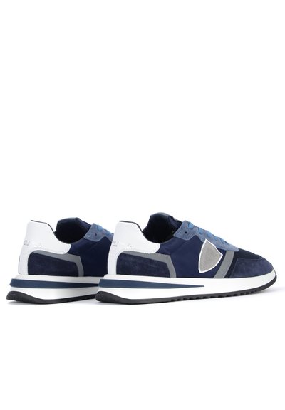 Baskets de sport bleu marine avec une tige en daim et en mesh, accents gris, contrefort blanc et semelle en caoutchouc noir texturé.