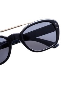 Svarta kattögon-solglasögon med mörka linser, guldtonad metallbro och smala skalmar med ribbat accentdetalj.