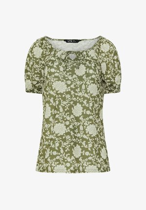 Blouse vert olive avec des manches courtes bouffantes, ornée d'un imprimé floral blanc et d'un détail de lien à l'encolure. Texture douce.